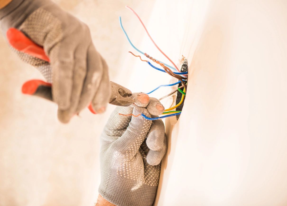 A person is working on wires in the house.