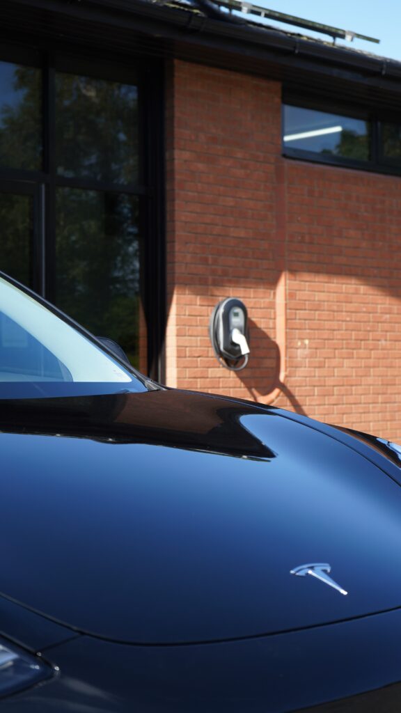 A close up of the side of a car with a parking meter.